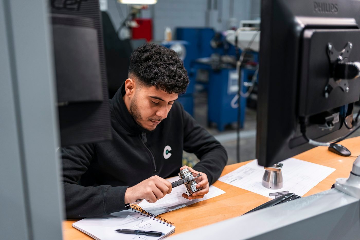 Engineer measuring a machined component (demonstration image)