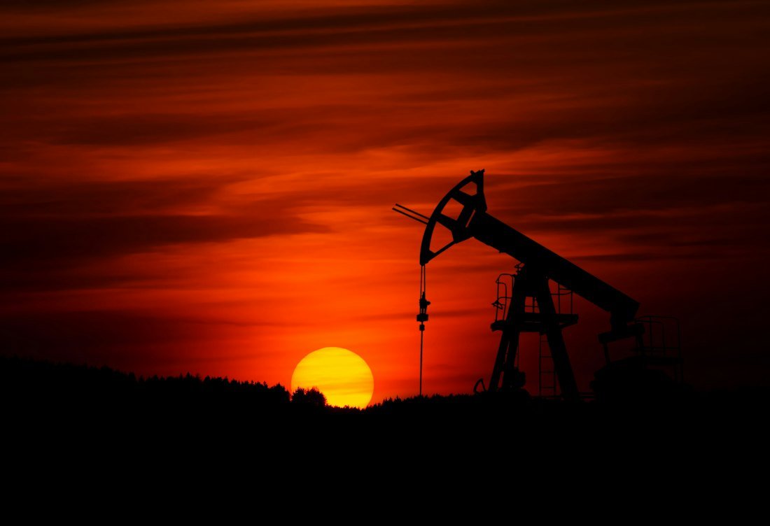Oil field pump jack at sunset (demonstration image)